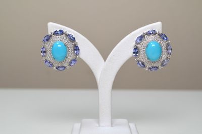 une paire de boucles d'oreilles ornées de pierres bleues sur un support blanc