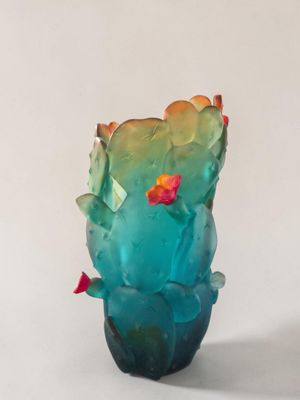 un vase en verre avec une fleur à l'intérieur sur une table