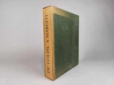 un vieux livre à la couverture verte posé sur une table blanche