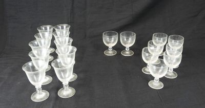 six verres à vin transparents sont alignés sur un fond noir