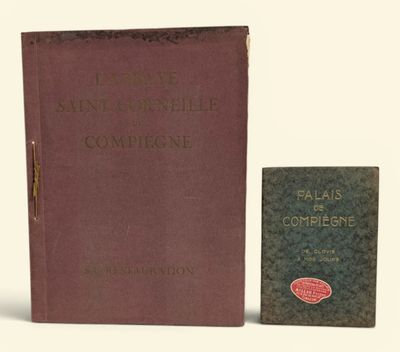 un vieux livre posé à côté d'un petit livre sur une surface blanche