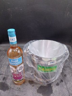 une bouteille d'alcool et un bol posés sur une table
