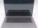 a silver laptop with a black keyboard on a white surface
