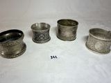 quatre tasses en argent sont alignées sur une surface blanche