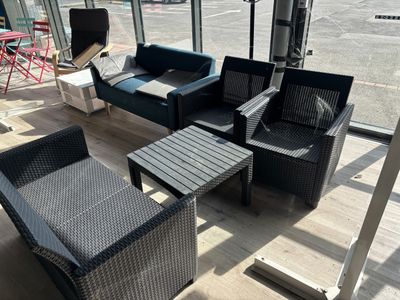 un canapé, un fauteuil, une table et une télévision dans une pièce