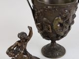 a bronze vase and a figurine on a table