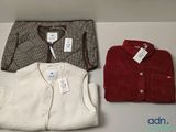 trois paires de pulls pour homme posées sur une table blanche