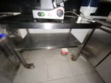 a small kitchen with stainless steel counter tops and a trash can