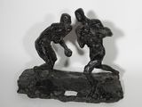 statue représentant deux hommes en train de lutter sur un rocher, sur fond blanc