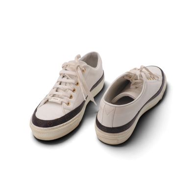 une paire de baskets blanches posées sur une surface blanche, avec un fond blanc