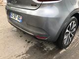 the rear end of a silver car parked on the side of the road