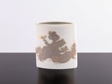 a white cup with gold designs on it on a table