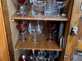 a wooden cabinet filled with wine glasses and wine glasses