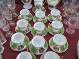 de nombreuses tasses et soucoupes posées sur une table recouverte d'une nappe rouge