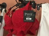 a red bra top hanging on a hanger in a store