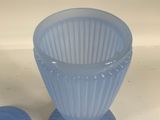 a blue glass vase and a blue cup on a table