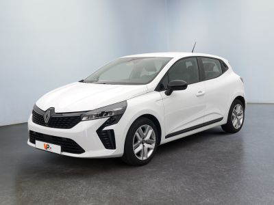 Une voiture blanche est garée dans une pièce au sol noir.