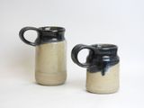 two black and white mugs sitting next to each other