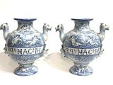 pair of blue and white vases sitting on top of a white surface