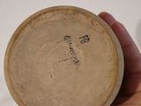 a person holding a small wooden object with writing on it