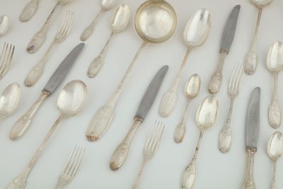 un grand nombre de cuillères et de fourchettes en argent disposées sur une table