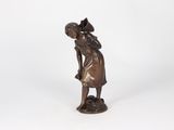 bronze statue of a woman with a basket on her head and a hat on her head