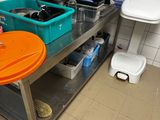 pots and pans are sitting on a metal table in a kitchen