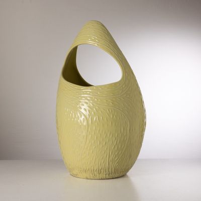 un vase jaune posé sur une table