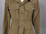 une veste verte posée sur un mannequin, sur un fond gris