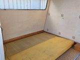 a bed in the corner of a room with a window
