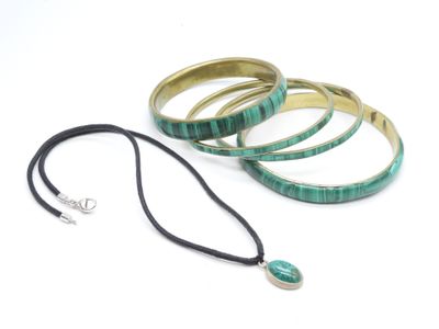 three bracelets and a necklace are sitting on a white surface