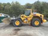 a picture of a yellow wheel loader parked in a parking lot