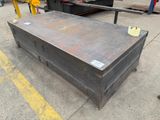 a large metal box sitting on the ground in front of a truck