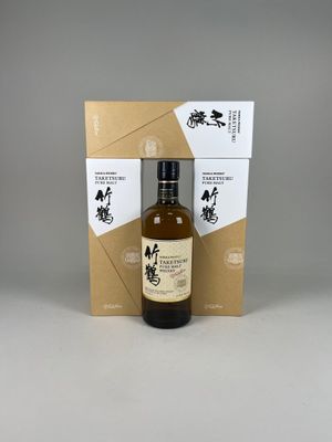une bouteille de whisky vide posée devant un carton