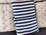 un coussin rayé bleu et blanc posé sur un canapé