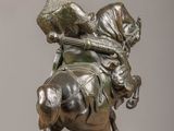 bronze statue of a man on a horse with a bird on his back