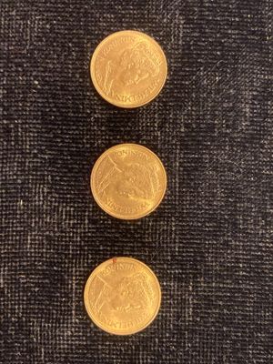 trois pièces d'or empilées les unes sur les autres sur un tissu noir