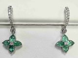 une paire de boucles d'oreilles en émeraude et diamant exposée dans une bijouterie