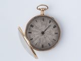 une montre de poche en or avec des chiffres romains sur le cadran