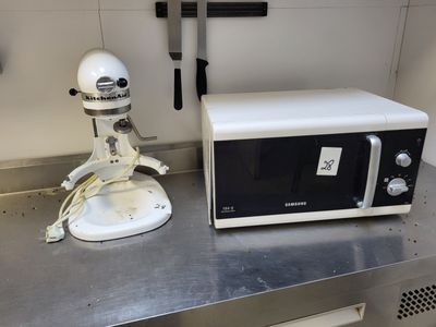 un mixeur blanc et un micro-ondes noir et blanc posés sur un plan de travail