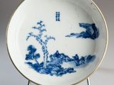 a blue and white plate with a landscape on it