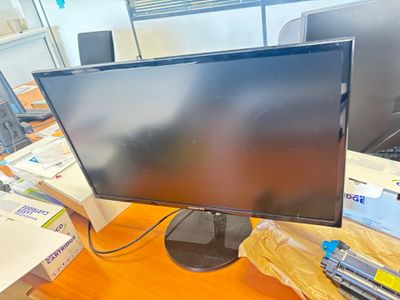un écran d'ordinateur posé sur un bureau en bois