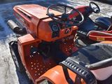a small orange tractor parked in a parking lot