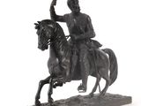 une statue représentant un homme à cheval sur fond blanc