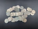 a pile of silver coins on a black surface