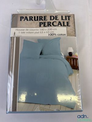 emballage d'un lit avec une couette bleue et deux oreillers