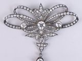 a close up of a brooch with diamonds on a white background