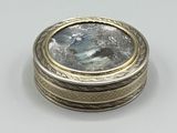 un gros plan d'une bague en argent et en or, ornée d'une pierre bleue au centre