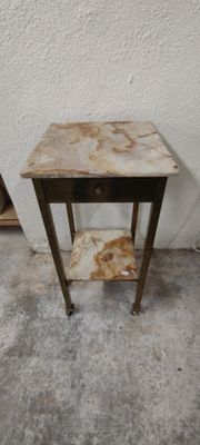 une petite table avec un tiroir, placée contre un mur