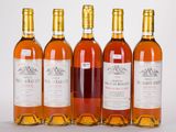 six bouteilles de vin sont alignées sur une surface blanche